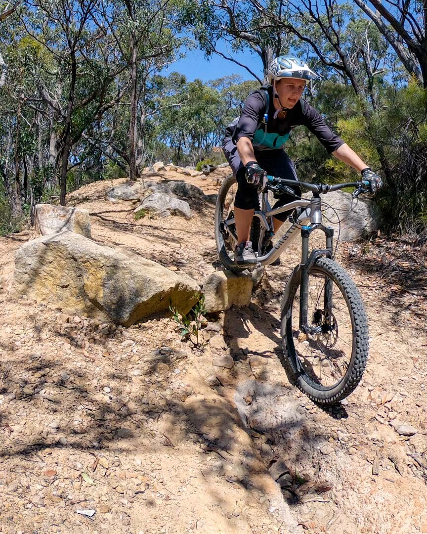Candace sending it down a rock section at Eagle mountain bike trails in Adelaide