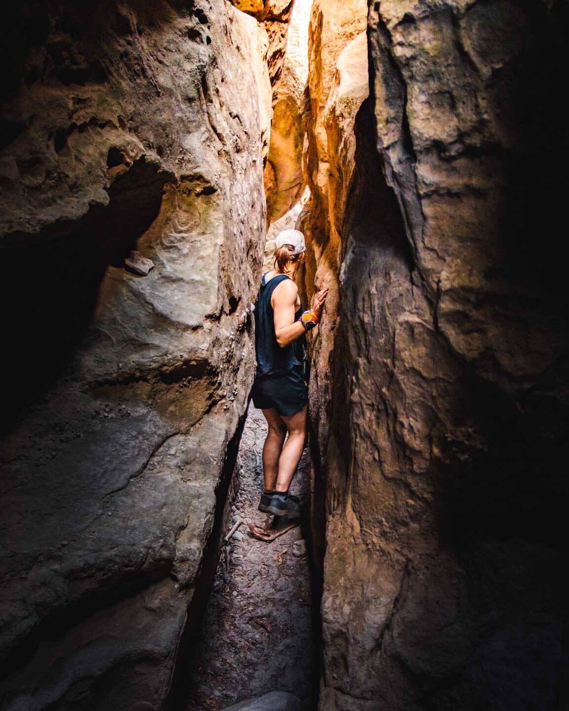 Sliding through the tight rock tunnel heading for the summit of The Castle in the Budawangs