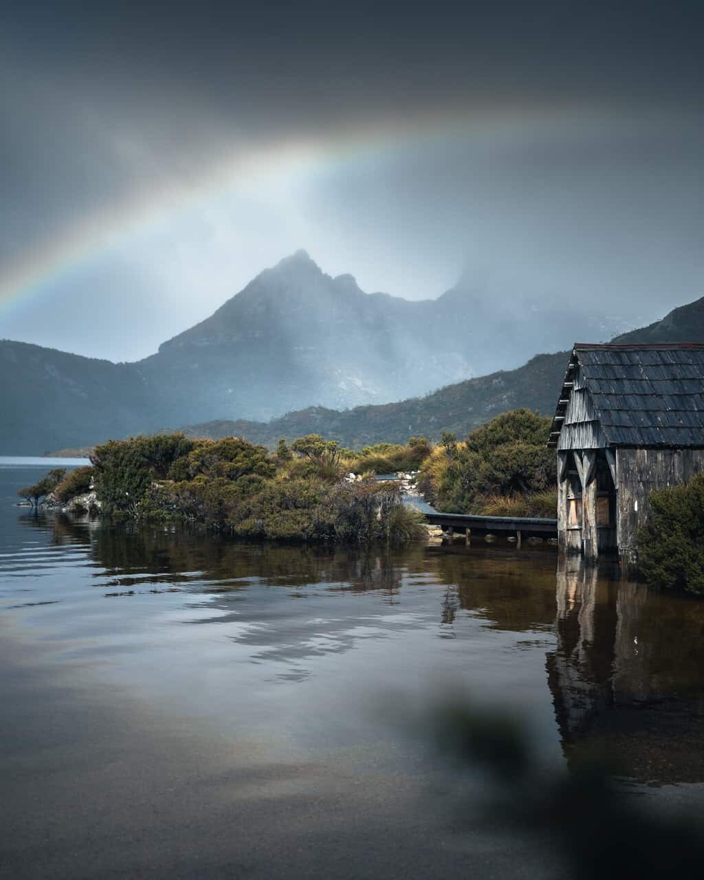 Epic rainbow over the boat shed on Dove Lake in Cradle Mountain, Tasmania