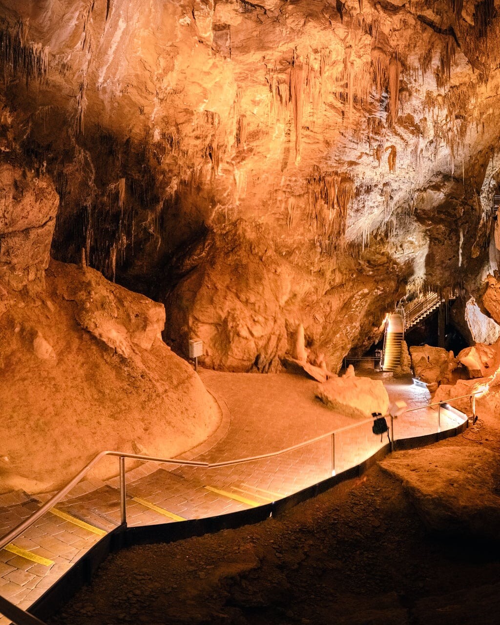 Hastings Caves large chamber of Newdegate Cave glowing in orange light