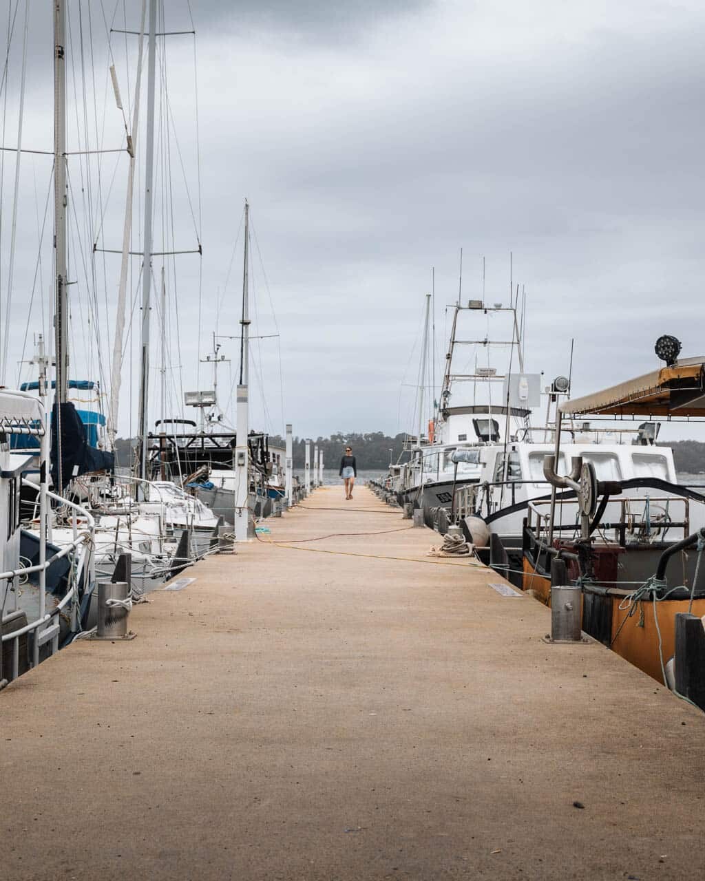 Walking down the busy wharf in St Helens Tasmania surrounded by local fishing boats
