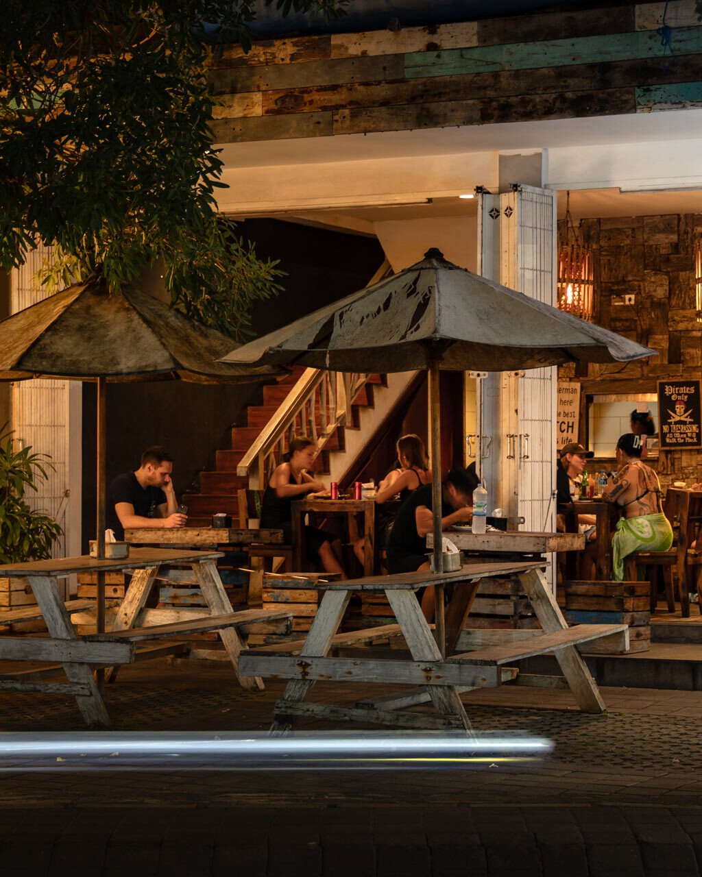 Scooter riding past the best Warung in Canggu at night